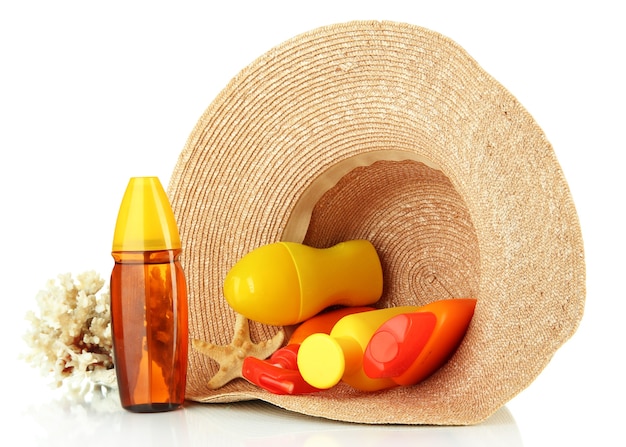 Bottles with suntan cream in hat isolated on white