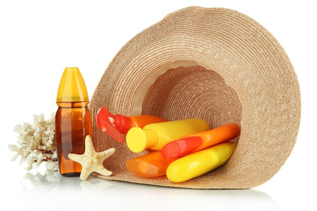 Bottles with suntan cream in hat isolated on white