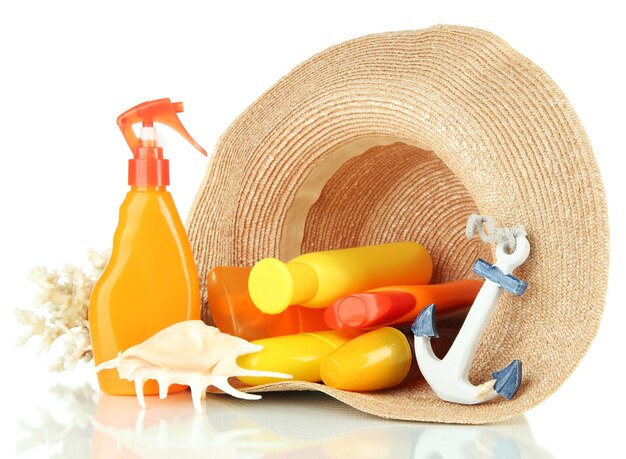 Bottles with suntan cream in hat isolated on white