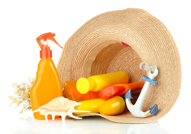 Bottles with suntan cream in hat isolated on white