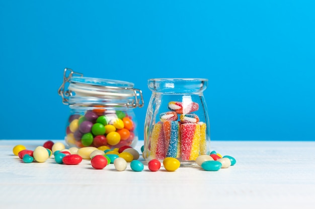 Bottles with sweet candies on table