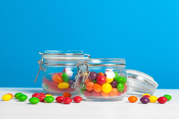 Bottles with sweet candies on table