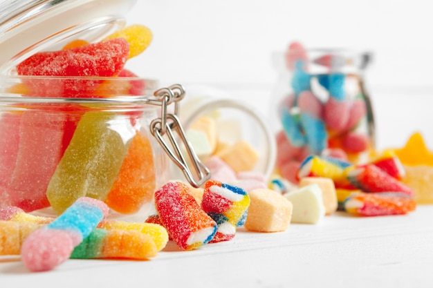 Bottles with sweet candies on table