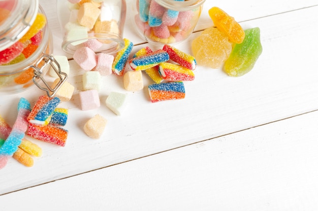 Bottles with sweet candies on table