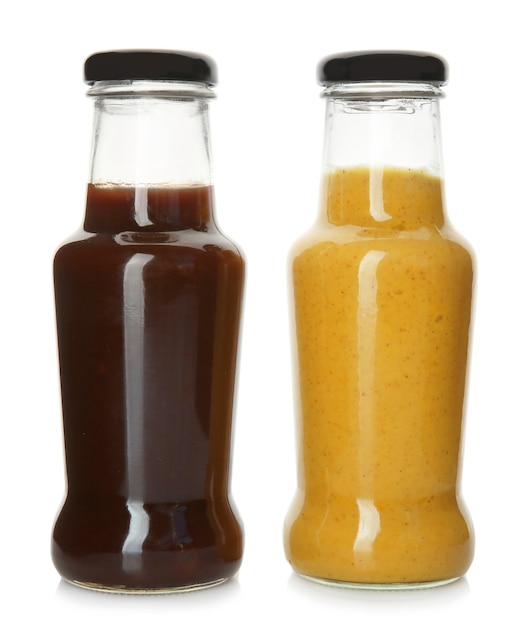 Bottles with tasty sauces on white