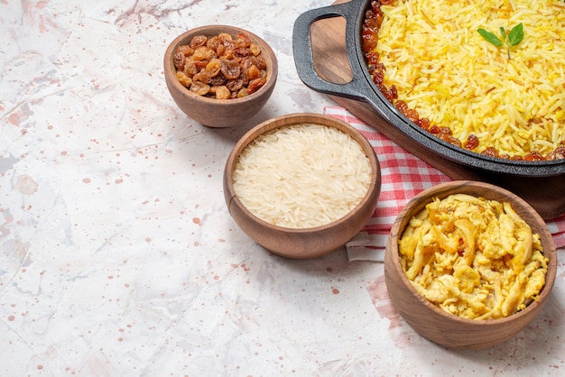 테이블에 나무 그릇에 큰 팬 마른 포도 쌀 치킨에서 아래쪽 절반 보기 맛있는 plov