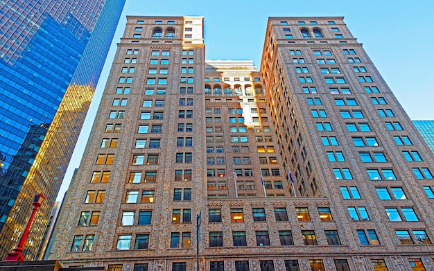 Bottom up Street view on Financial District of Lower Manhattan, New York City, NYC, USA. Skyscrapers tall glass buildings United States of America. Blue sky on background. Empty place for copy space.