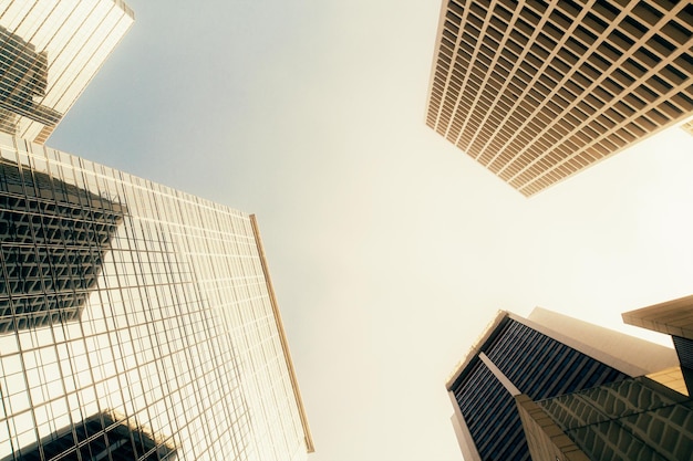 Bottom view of buildings on bright blue sky background Urban and corporate concept