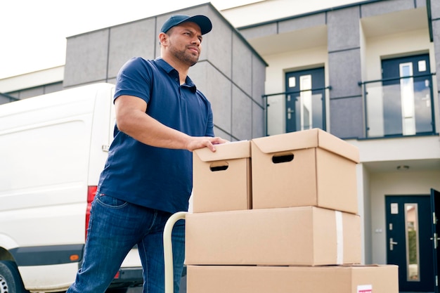 bottom view of courier going with packages on a hand truck