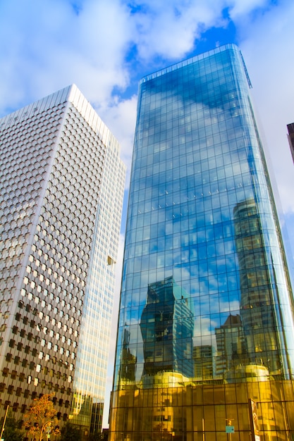 Photo bottom view of the glass skyscrapers of the business district of paris la defense against a blue cloudy sky