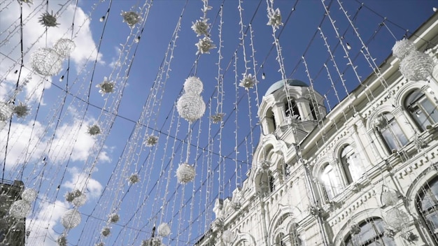 Photo bottom view of hanging decorations against blue sky with white clouds action moscow russia