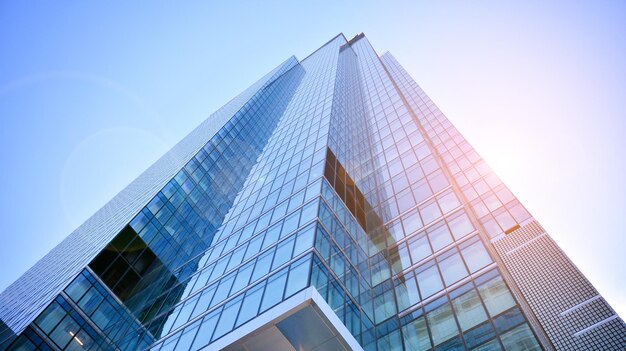 青い空を背景にビジネス地区の近代的な高層ビルの底面図