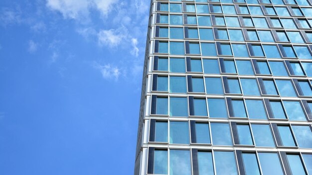 Bottom view of modern skyscrapers in business district against blue sky looking up at business