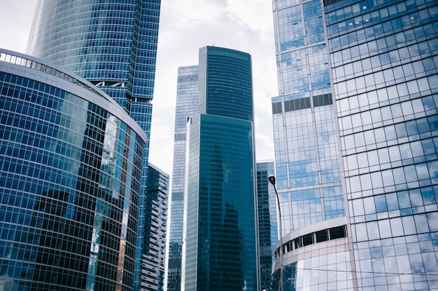 雲の反射を伴う未来的なデザインのモスクワ市の高層ビルの底面図