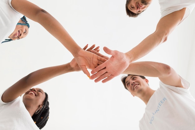 Photo bottom view people placing their hands on each other