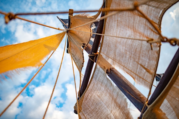 Bottom view of a ship mast with beige sails