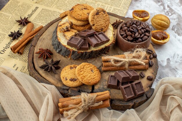 bottom view wood rustic board with cookies bowl with roasted coffee beans chocolate cinnamon sticks on table