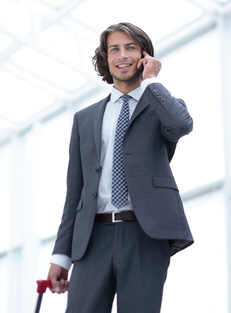 Bottom viewbusinessman with Luggage talking on a cellphoto with copy space