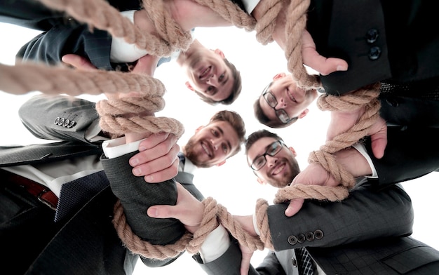 Foto vista dal basso un team aziendale unificato che tiene una forte corda in primo piano