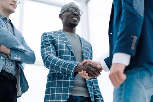 Bottom viewyoung businessman shaking hands with his business partner