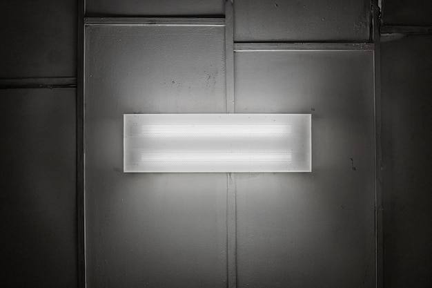 Bottomup view of a fluorescent lamp on the ceiling in a decorative plastic box with a metal suspended ceiling in an old Soviet building