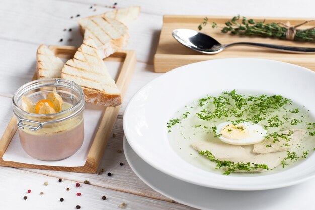 Bouillon met ei en foie gras op tafel.