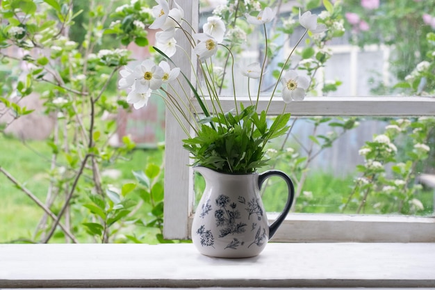 Bouquet of anemones flowers on window in countryside