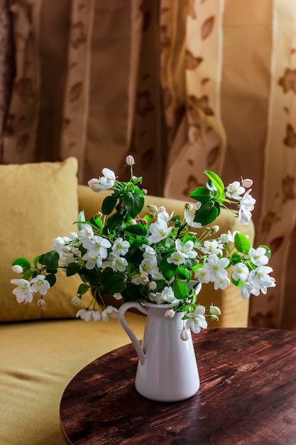 Bouquet of apple flowers on a wooden table in a cozy apartment