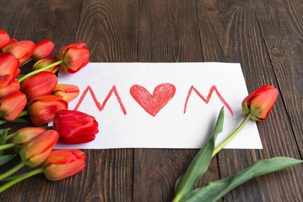 Bouquet of beautiful fresh orange tulips with a holiday card