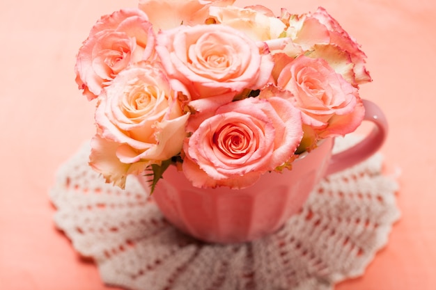 핑크 컵에 아름 다운 신선한 핑크 장미 꽃다발