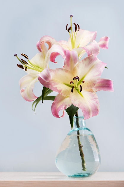 Bouquet of beautiful lilies in vase on the table.