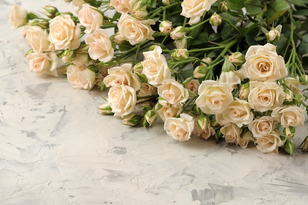 A bouquet of beautiful tender mini roses on a light concrete surface