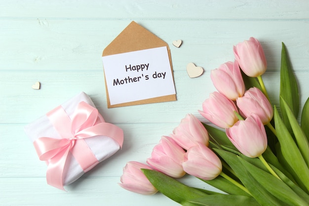 A bouquet of beautiful tulips and a card for text on a wooden background