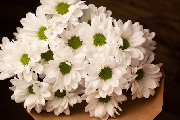 Bouquet of beautiful white chrysanthemums in craft paper.