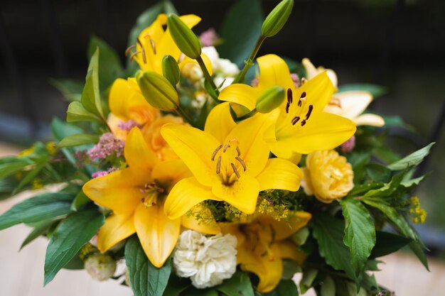 A bouquet of beautiful yellow flowers in a vase outdoors