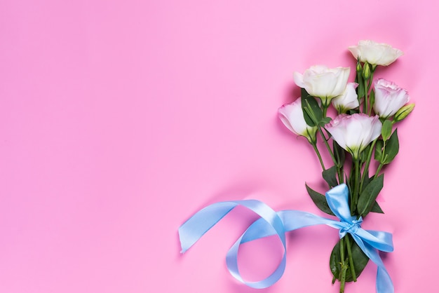 Eustoma rosa di fioritura del mazzo su fondo rosa, disposizione piana. cartolina d'auguri di san valentino, compleanno, madre o matrimonio