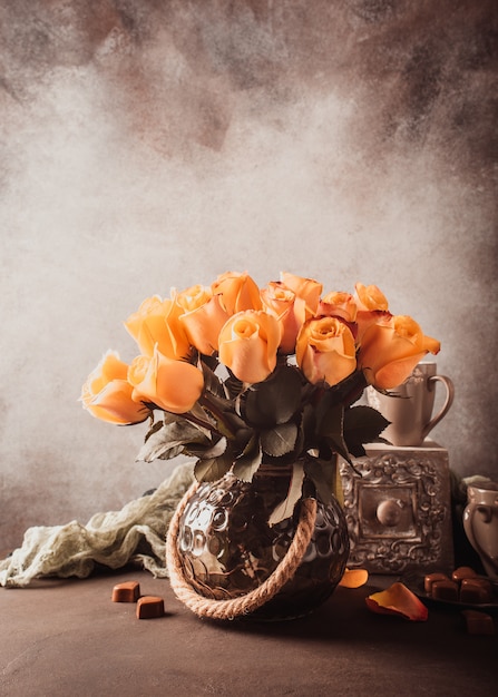 Photo bouquet of blossoming yellow roses in vintage vase.