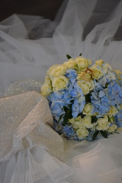 Photo a bouquet of blue flowers is in a white tulle.