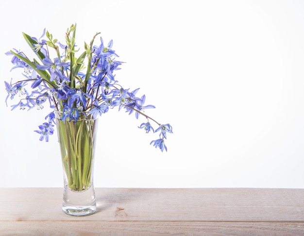 오래 된 나무 테이블에 빈티지 은색 마음으로 블루 Scilla Squill 꽃의 꽃다발과 선물 상자. 해피 어머니의 날 또는 봄 휴일 장식입니다. 어머니의 날을 위한 봄 꽃. 선택적 초점.