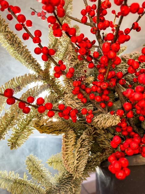 A bouquet of branches with red berries and fir branches in smoke in sunny weather the rays of the