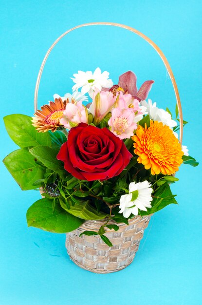 Bouquet of bright beautiful flowers on blue surface