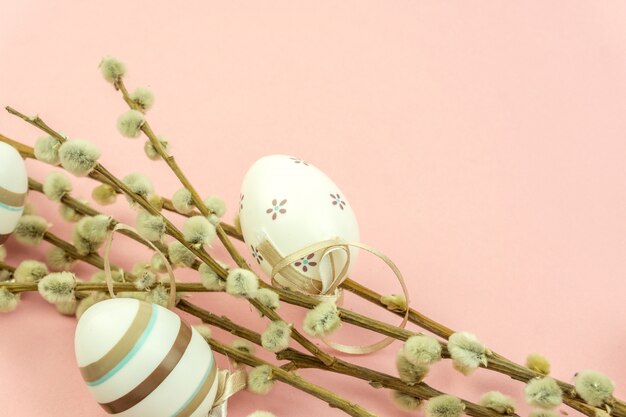 Bouquet of catkins and easter eggs on pink background