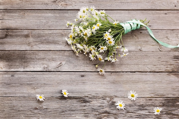 Bouquet of chamomile on old wooden background