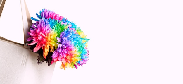 A bouquet of colored chrysanthemums in a white bag on a white background