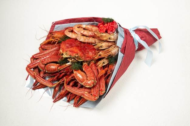 Bouquet consisting of boiled crayfish shrimps and a large crab on a white background