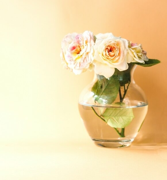 Bouquet of cream tea roses in glass vase