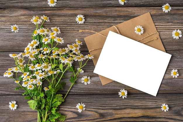 A bouquet of daisies and a card on a wooden table