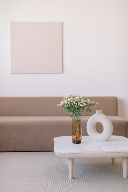 Foto un bouquet di margherite in un elegante vaso di vetro su un tavolo di design all'interno della casa