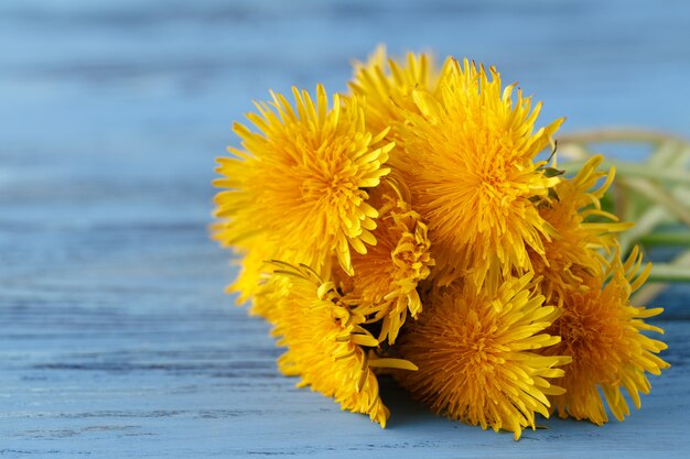 Bouquet of dandelions on wooden table