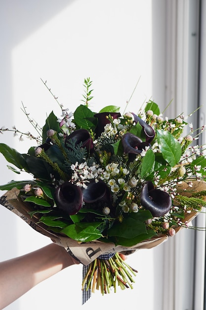 A bouquet of dark noble cal with frosted flower Floral